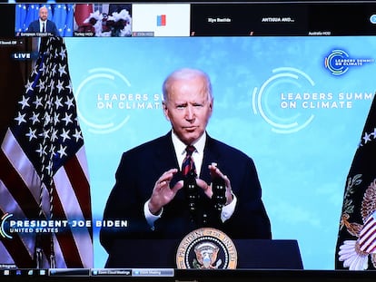 US President Joe Biden is seen on the screen as he attends the leaders summit on climate via video conference, in Brussels on April 22, 2021. (Photo by JOHANNA GERON / POOL / AFP)