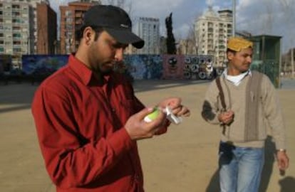 Un jugador envuelve una pelota de tenis con cinta aislante para jugar a críquet.