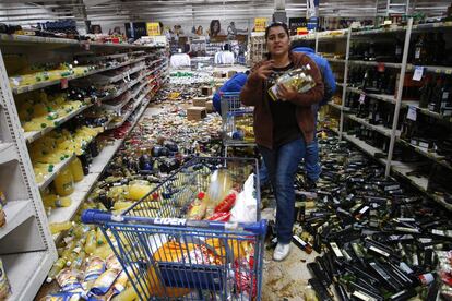 Um grupo de pessoas saqueia um supermercado um dia após o terremoto no Chile.