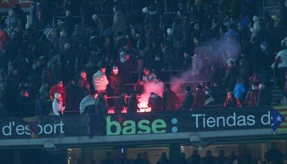 Una bengala cae junto a un grupo de aficionados del Real Madrid durante la semifinal de Copa en el Camp Nou
