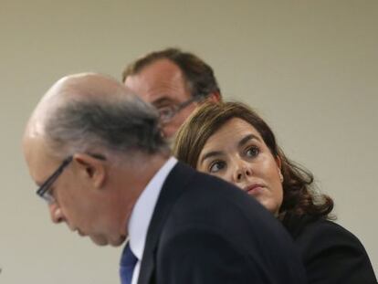 Soraya S&aacute;enz de Santamar&iacute;a, junto a los ministros de Hacienda, Crist&oacute;bal Montoro , y Sanidad, Alfonso Alonso (detr&aacute;s), durante la rueda de prensa posterior a la reuni&oacute;n del Consejo de Ministros celebrada en el Palacio de la Moncloa.