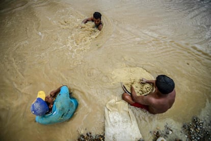 Hombres trabajan en la mina de oro de Nacupay, a las orillas de un río, en El Callao.