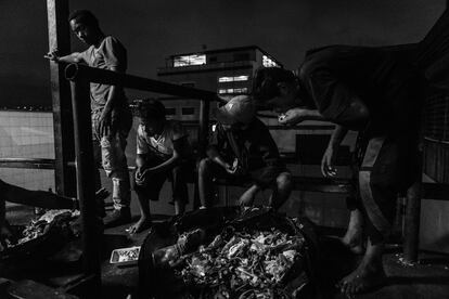 Um grupo de crianças procura comida entre o lixo de um grande centro comercial. Segundo a Cáritas, 53% das famílias foram obrigadas a procurar por alimentos em "lugares não convencionais", o que costuma ser um eufemismo para se referir aos resíduos.