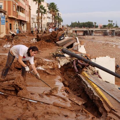 A woman sweeps mud off the street following heavy rains that caused floods, in Paiporta, near Valencia, Spain, November 1, 2024. REUTERS/Nacho Doce     TPX IMAGES OF THE DAY