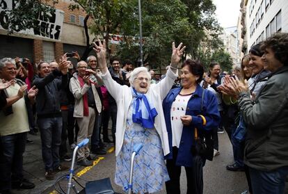 Una anciana es aplaudida por el público que espera fuera de un colegio electoral del barrio de Gràcia.