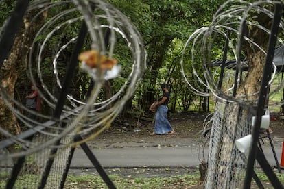 A woman walks past a military checkpoint in Tonacatepeque, El Salvador