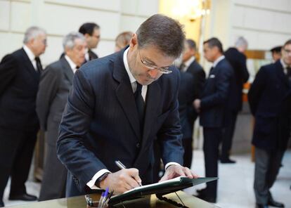 El ministro de Justicia Rafael Catalá, firma en el libro de condolencias en la capilla ardiente del fiscal general del Estado.