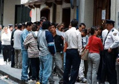 Inmigrantes hacen cola en Alicante, ayer, ante la oficina de Extranjería.