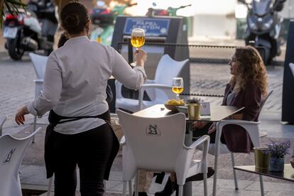 Una empleada de un bar de Sevilla, sirve una cerveza.