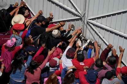 Manifestantes empujan la puerta principal del edificio de la  Dirección General Adjunta de Recursos Humanos de la Autoridad Educativa Federal, en Ciudad de México este jueves.