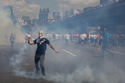 Un manifestante devuelve un bote de gas lacrimógeno durante el enfrentamiento con la Policía Nacional Bolivariana (PNB), en una protesta contra el gobierno de Nicolás Maduro, en Caracas (Venezuela).