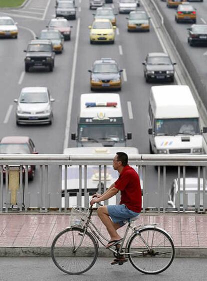 Un ciclista pedalea en un puente sobre un atasco de tráfico en Pekín