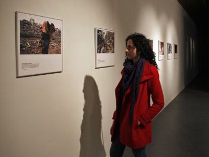 Una mujer recorre la exposición 40 Años de Acción Humanitaria Internacional en el Centre Cultural La Nau de Valencia.