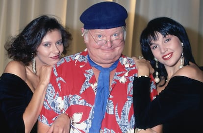 Benny Hill durante una visita a Madrid en 1991, posando con dos azafatas de Telecinco.