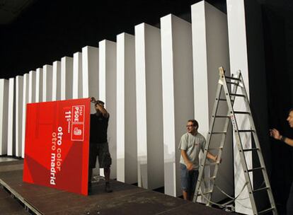 Operarios montan el escenario del XI Congreso Regional del PSM, en el palacio de Exposiciones de la Castellana.