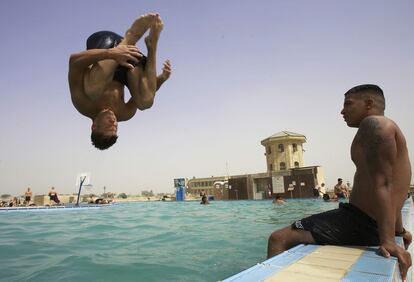 Fotografía datada en junio de 2005 en la que dos soldados estadounidenses saltan en la piscina de la Base Victoria. Antes de la ocupación de EE UU en 2003, el complejo estaba destinado a una extensa zona de ocio reservada a la élite del régimen de Sadam Husein.