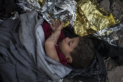 Un niño sirio durmiendo en el puerto de Mytilene, Lesbos. Lleva el teléfono de sus padres escrito en el brazo.
