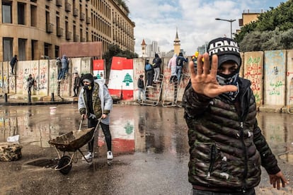 Vários manifestantes tentam atravessar as barreiras de concreto erguidas em 11 de fevereiro para impedir que civis entrem no Parlamento libanês, em Beirute.