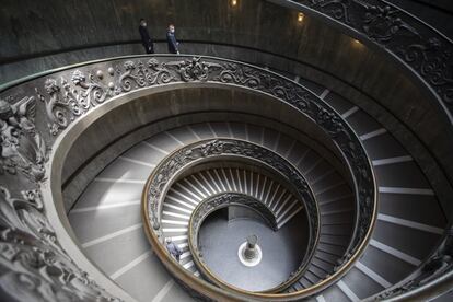 Empleados de los Museos Vaticanos, que ya han reabierto, bajan por una escalera diseñada por Giuseppe Momo en 1932, inspirada en la escalera original del arquitecto renacentista Bramante.