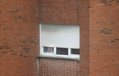 Un amujer aislada mira por la ventana del Carlos III