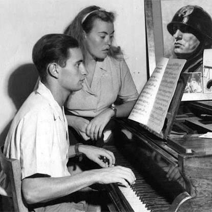 Romano Mussolini, con su hermana Ana María, en 1962, con una foto de su padre al fondo, encima del piano.