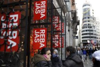 Varias personas ante un comercio en rebajas en la Gran V&iacute;a de Madrid.