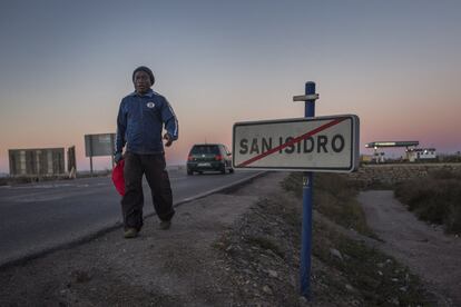 Un trabajador africano camina por la carretera a las afueras del pueblo de San Isidro, una de las zonas que registra una mayor concentración de invernaderos en el municipio de Níjar, Almería.