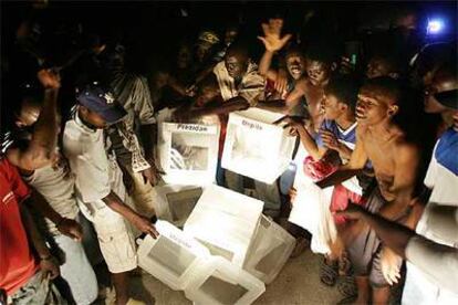 Seguidores del candidato René Préval muestran urnas halladas en un vertedero, ayer en Puerto Príncipe.
