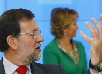 Mariano Rajoy, presidente del PP, delante de la presidenta regional, Esperanza Aguirre, en la reunión de la Junta Directiva Nacional de los populares celebrada ayer.