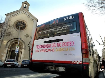 El autobús 41 con publicidad sobre ateísmo circula ante una iglesia en la calle Londres, en Barcelona.
