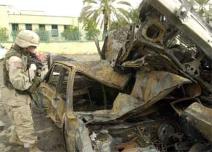 Un soldado norteamericano inspecciona los restos del coche bomba que ha explotado en la localidad de Samarra.