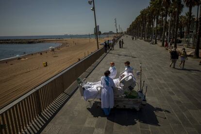 Francisco España, de 60 años, contempla el mar Mediterráneo desde su cama hospitalaria acompañado del personal médico del hospital del Mar, en Barcelona (España). El país se mantiene en la novena posición mundial y es ya el país de la Unión Europea con más casos por coronavirus, con 498.989 positivos y 29.418 muertos.