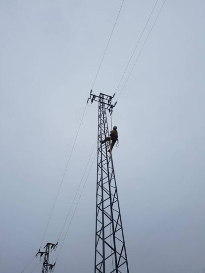 Tecnico en una torre de alta tensión.
