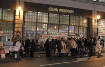 Una treintena de personas frente a la sede de la obra social de Bankia, en Madrid, para pedir la dación en pago y protestar por los desahucios. EFE/Archivo