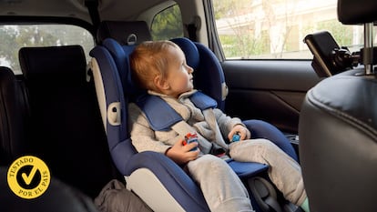 Un niño pequeño en un coche mirando por la ventana y montado en su silla.