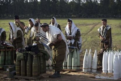 Soldados israel&iacute;es rezan junto a la artiller&iacute;a antes de un despliegue sobre Gaza. 