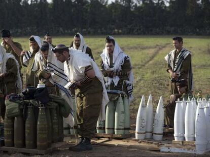 Soldados israel&iacute;es rezan junto a la artiller&iacute;a antes de un despliegue sobre Gaza. 