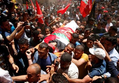 Varias personas portan el cuerpo del pescador palestino Mohamed Baker durante su funeral en la Ciudad de Gaza.