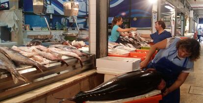 Lisboa. María pasa a cuchillo un atún en el animado mercado de la Ribeira.
