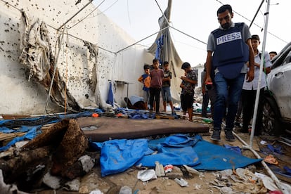 Un periodista inspecciona la tienda donde trabajaban los cuatro reporteros frente al hospital Al Shifa de la Ciudad de Gaza, este lunes.