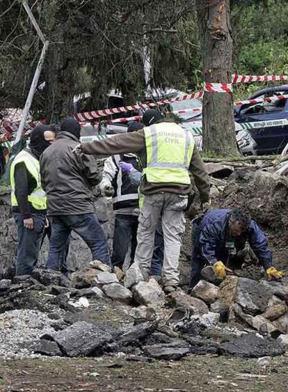 Varios agentes inspeccionan entre los escombros.