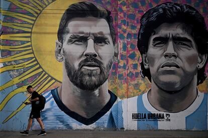 Un viandante pasa enfrente de un mural con Lionel Messi y Diego Maradona en Buenos Aires.