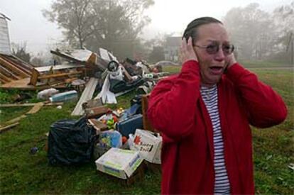 Una mujer se lleva las manos a la cabeza frente a su casa destruida por el tornado.