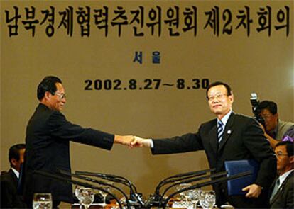 El delegado norcoreano Park Chang Nyon (izquierda) estrecha la mano del surcoreano Yoon Jin-shik tras firmar el acuerdo.