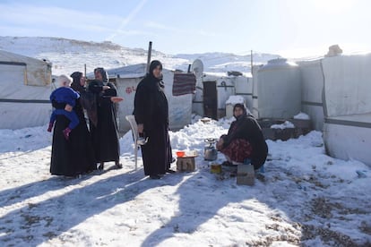 La vecinas de un asentamiento informal en Líbano preparan un infusión de mate a las puertas de sus tiendas entre los restos de nieve tras el paso de la Tempestad Norma.