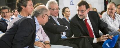 Rajoy, se dirige al ministro de Hacienda, Cristóbal Montoro, en presencia del presidente del PP de Murcia, Ramón Luís Valcarcel, y Carlos Floriano, en Murcia.