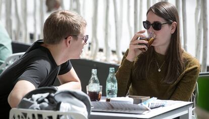 Dos jóvenes beben un refresco en Barcelona.