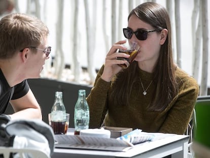 Dos joves beuen un refresc a Barcelona.