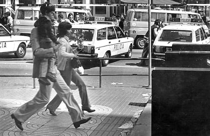 Una pareja con su hijo cruza por la plaza de Catalunya.