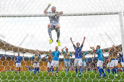 Buffon subido en el larguero mientras la selección celebra la victoria contra Suecia en junio de 2016 durante la Eurocopa de Francia. 